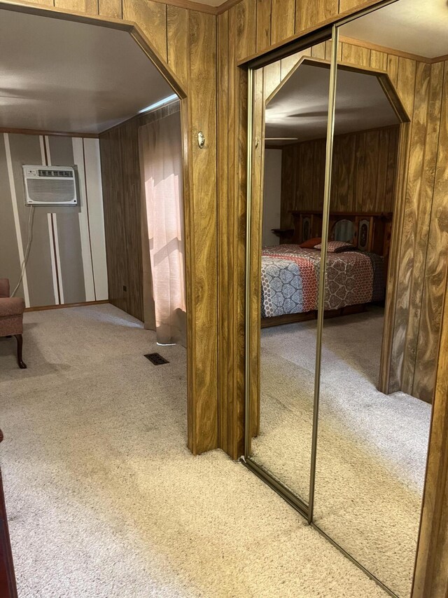 8181 15 Mile Rd, Evart, MI 49631 - carpeted bedroom featuring arched walkways, wooden walls, an AC wall unit, and a closet