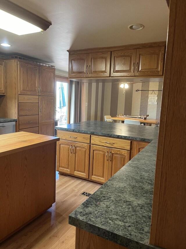 8181 15 Mile Rd, Evart, MI 49631 - kitchen with light wood-type flooring, a peninsula, recessed lighting, and brown cabinets