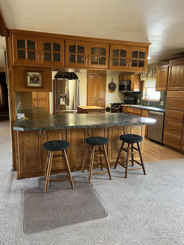 bar featuring light carpet, sink, and appliances with stainless steel finishes