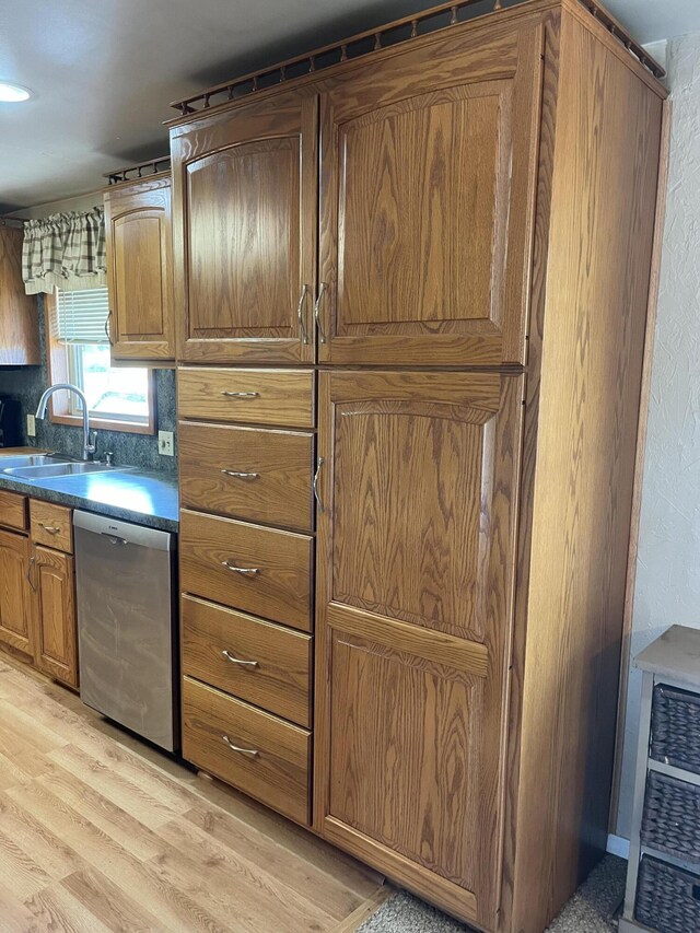 8181 15 Mile Rd, Evart, MI 49631 - kitchen featuring dishwasher, a sink, light wood-style flooring, brown cabinets, and dark countertops