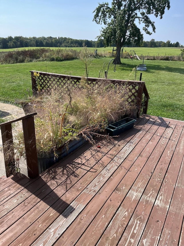 wooden deck featuring a rural view and a lawn