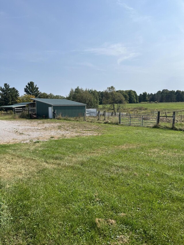 8181 15 Mile Rd, Evart, MI 49631 - view of yard featuring a pole building, a view of countryside, and an outbuilding