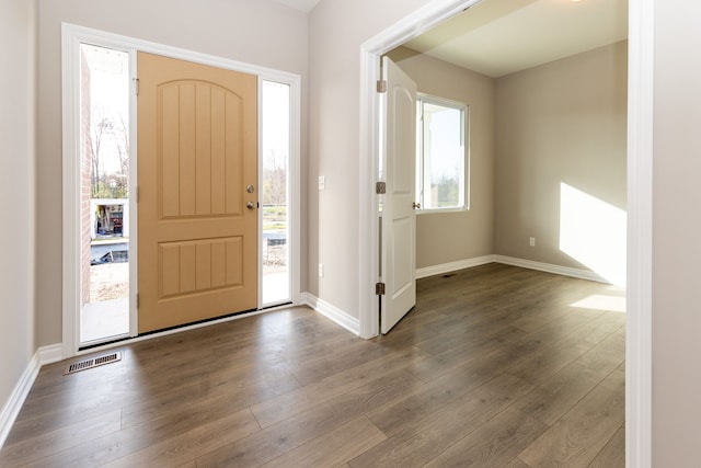 entryway featuring baseboards, dark wood-style flooring, visible vents, and a healthy amount of sunlight