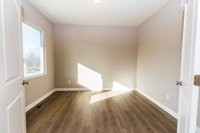 empty room with visible vents, baseboards, and wood finished floors