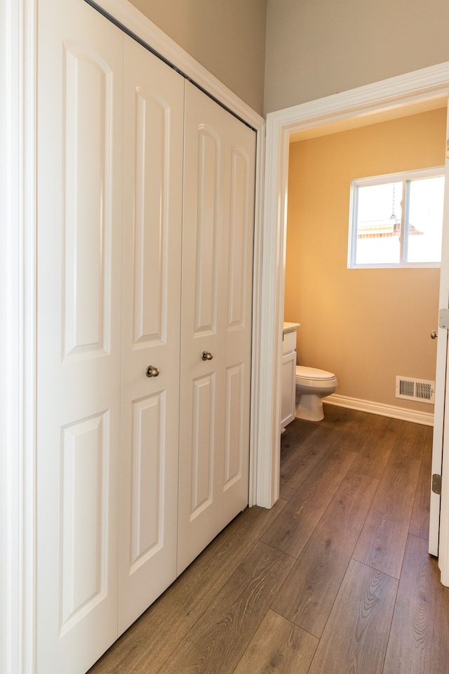 bathroom with toilet, baseboards, visible vents, and hardwood / wood-style floors