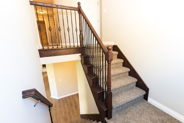 stairs with wood finished floors and baseboards