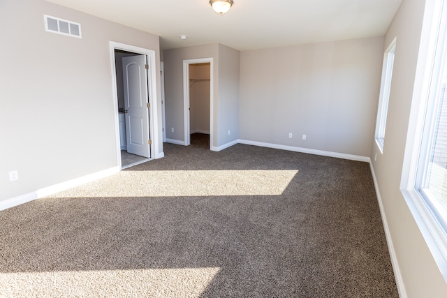 unfurnished bedroom featuring carpet flooring, visible vents, and baseboards