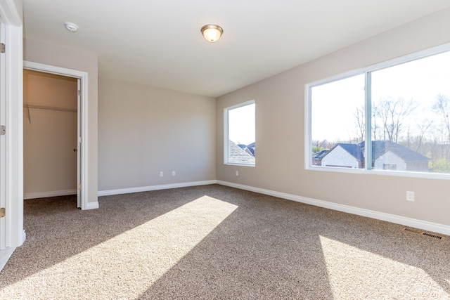 carpeted bedroom featuring baseboards, visible vents, and a closet