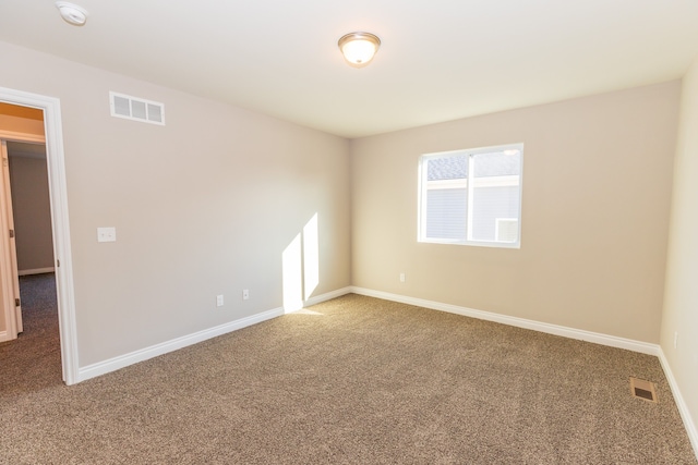 carpeted spare room featuring visible vents and baseboards