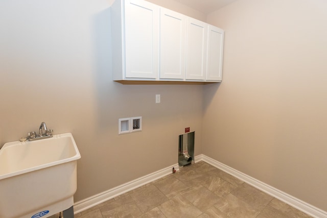 laundry area featuring washer hookup, cabinet space, a sink, and baseboards