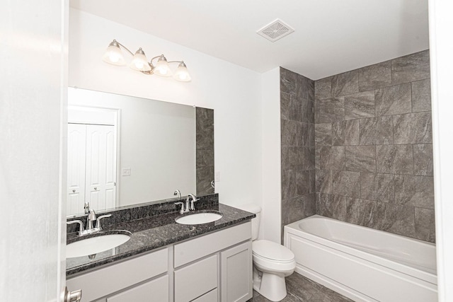 bathroom featuring visible vents, a sink, toilet, and double vanity