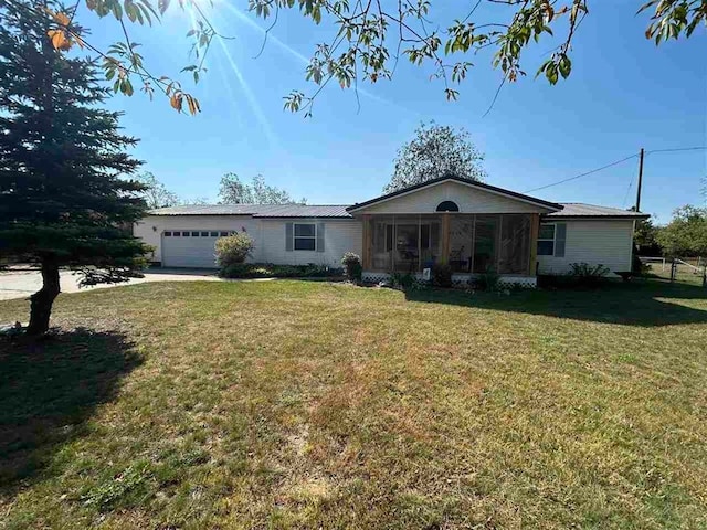 single story home with a sunroom, a front yard, and a garage