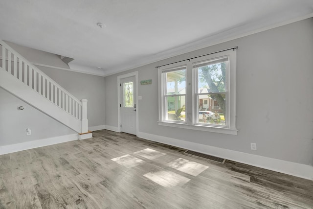 foyer entrance with crown molding and hardwood / wood-style floors