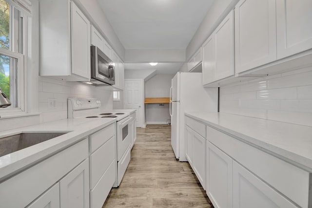 kitchen with white cabinetry, light hardwood / wood-style flooring, a healthy amount of sunlight, and white appliances