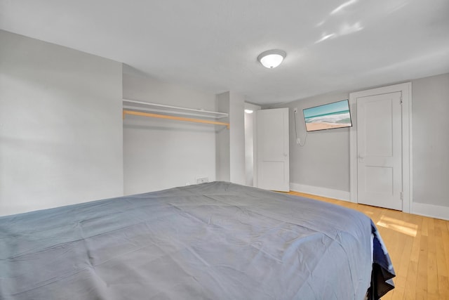 unfurnished bedroom with a closet and light wood-type flooring