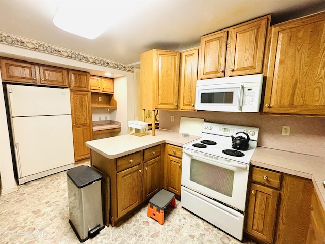 kitchen with brown cabinetry, white appliances, light countertops, and a peninsula