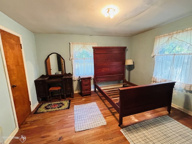 bedroom with baseboards and wood finished floors