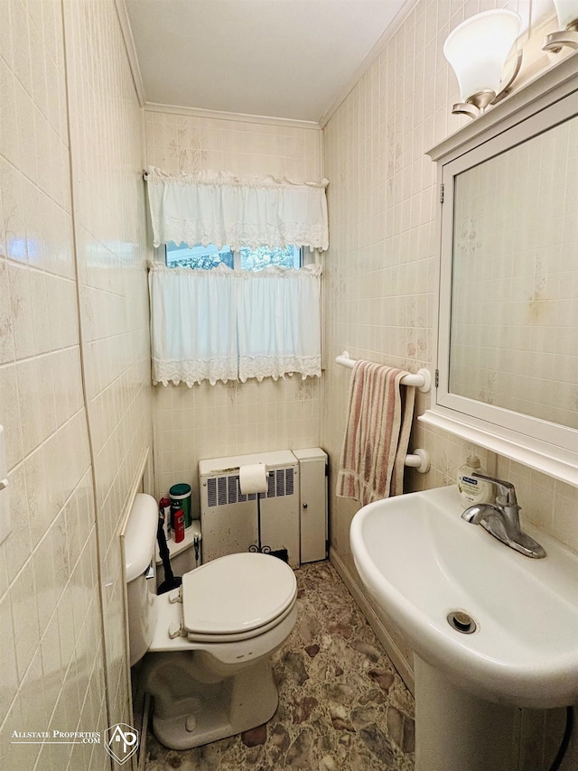 half bath featuring toilet, tile walls, radiator, and a sink