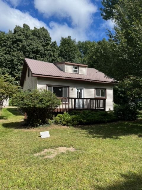 back of property with a lawn and a wooden deck