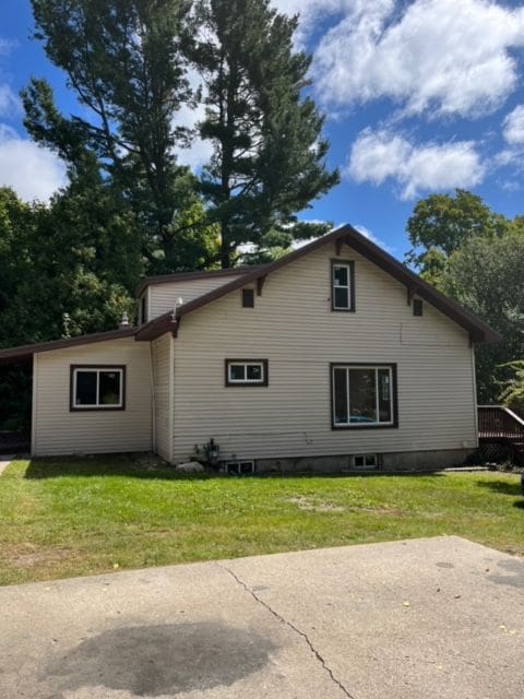 view of home's exterior with a yard and a carport