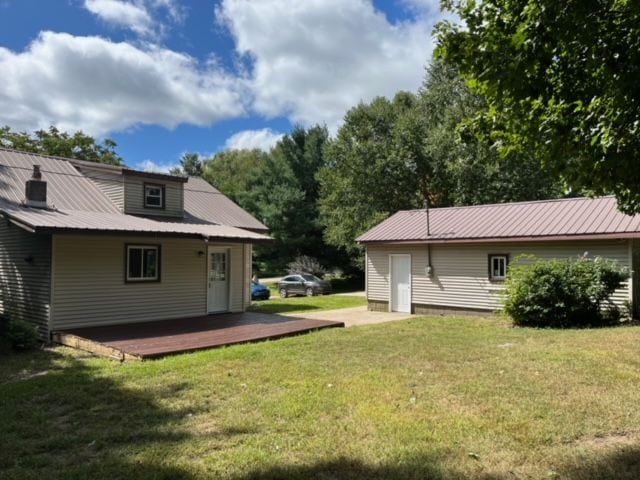 rear view of house featuring a deck and a lawn