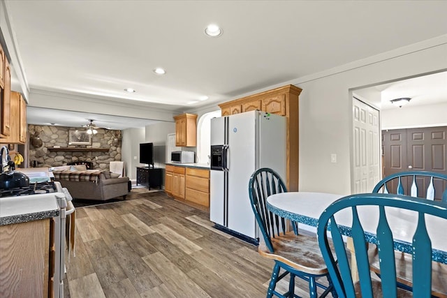 kitchen featuring a fireplace, white appliances, ceiling fan, and dark wood-type flooring