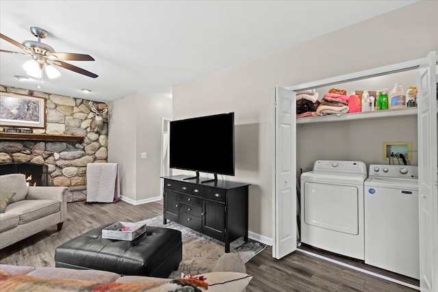 living room featuring ceiling fan, a fireplace, washer and dryer, and dark hardwood / wood-style floors