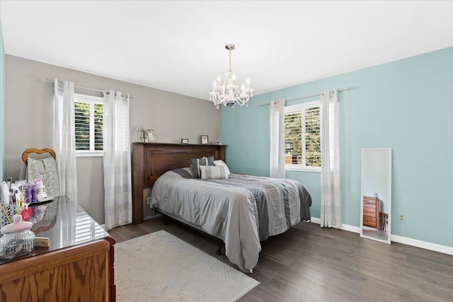 bedroom featuring an inviting chandelier, multiple windows, and dark wood-type flooring