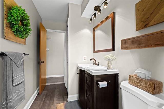 bathroom featuring hardwood / wood-style flooring, vanity, and toilet