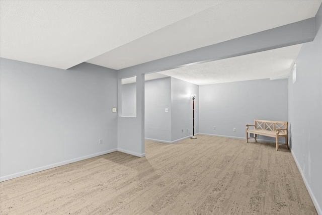 basement with light wood-type flooring and a textured ceiling