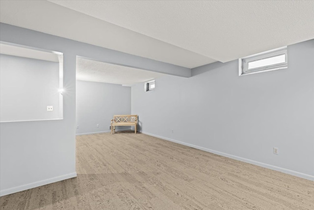 basement with a textured ceiling and hardwood / wood-style flooring