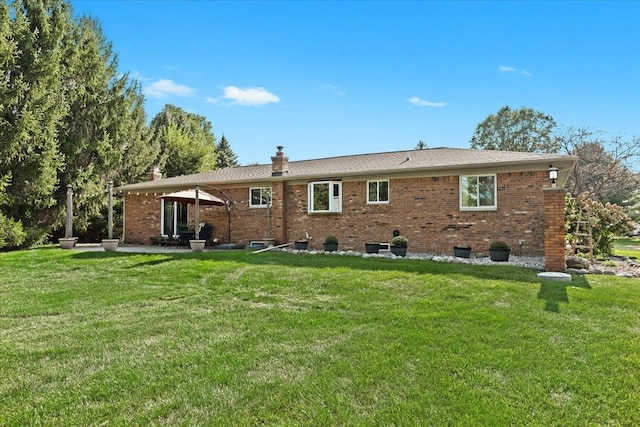 back of property with a lawn and a patio