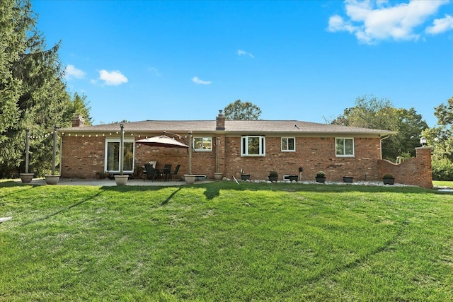 rear view of property with a patio and a lawn