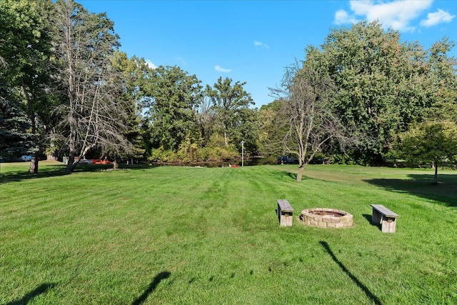 surrounding community with a yard and a fire pit