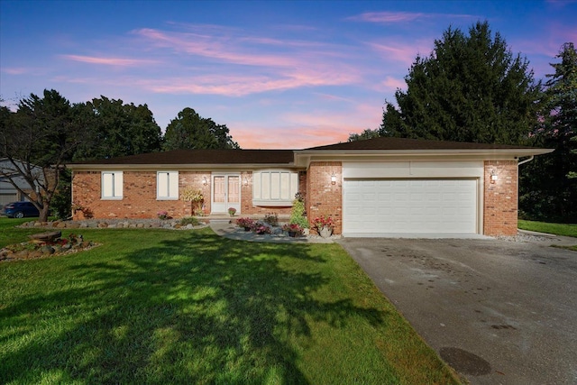 ranch-style house featuring a lawn and a garage