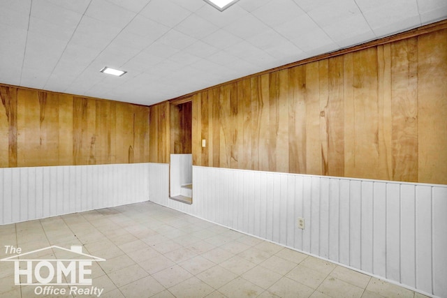 unfurnished room featuring wood walls