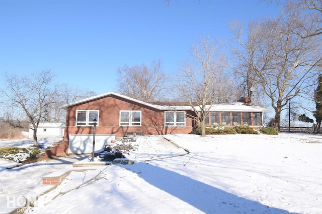 view of front of property featuring brick siding and a sunroom