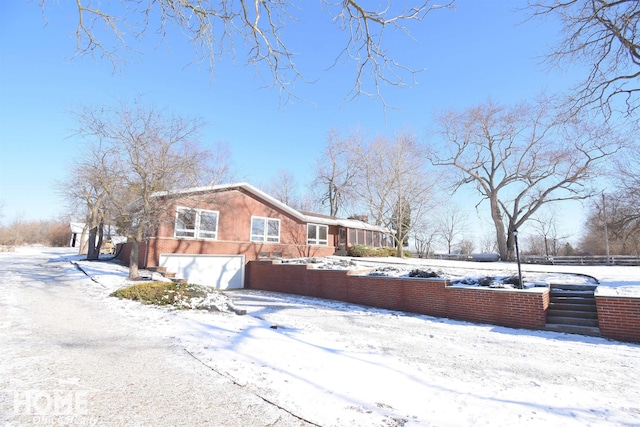 snow covered property with a garage