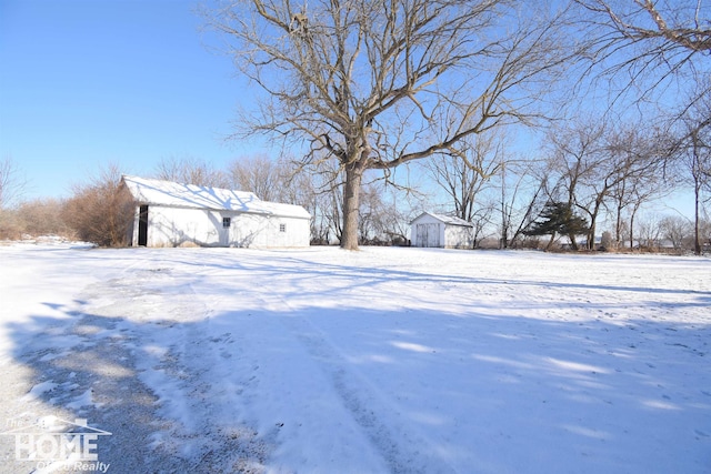 yard layered in snow featuring an outbuilding