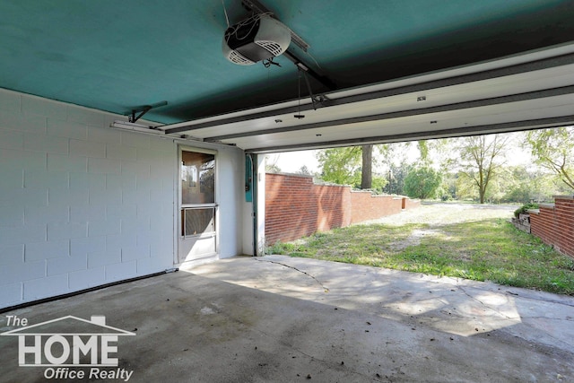 garage with a garage door opener and fence