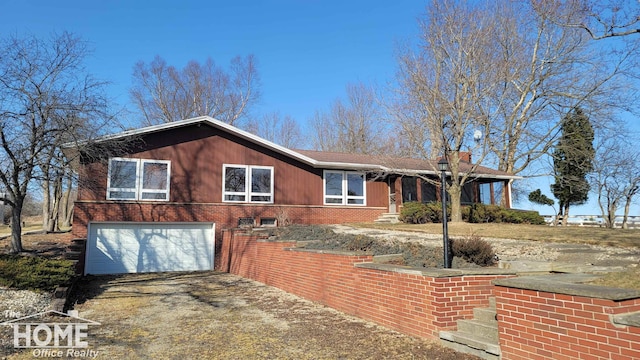 ranch-style home featuring brick siding, driveway, and a garage