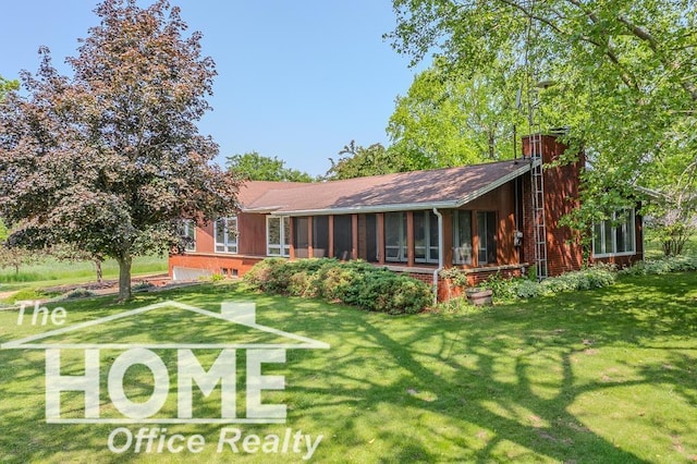 8102 Britton Rd, Perry, MI 48872 - back of property featuring a sunroom, a chimney, a yard, and an attached garage