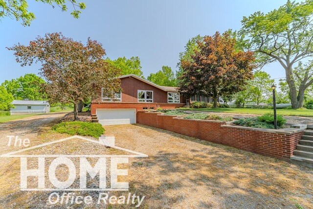 8102 Britton Rd, Perry, MI 48872 - view of front of home with dirt driveway and an attached garage