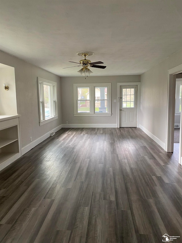 unfurnished living room with ceiling fan and dark hardwood / wood-style floors