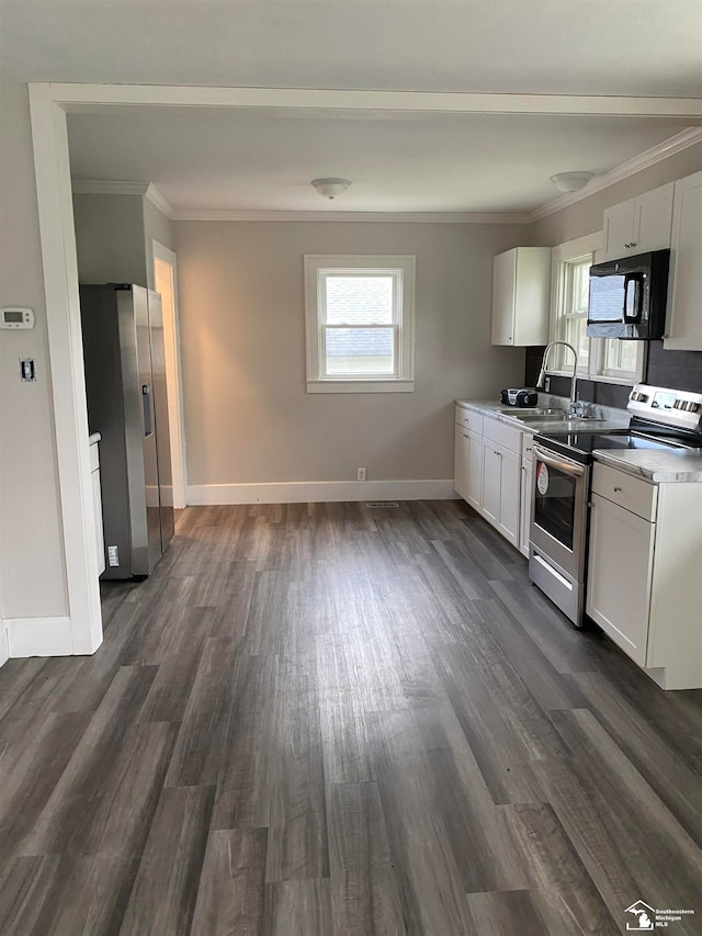 kitchen with dark hardwood / wood-style flooring, ornamental molding, stainless steel appliances, sink, and white cabinets