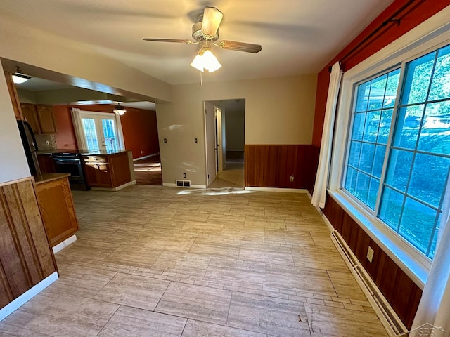 interior space with french doors, baseboard heating, plenty of natural light, and ceiling fan