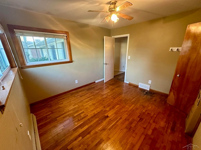 empty room featuring ceiling fan and hardwood / wood-style floors