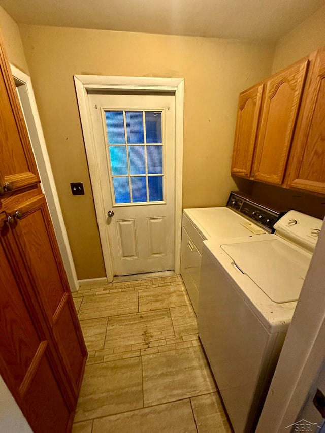 laundry room with washer and dryer and cabinets