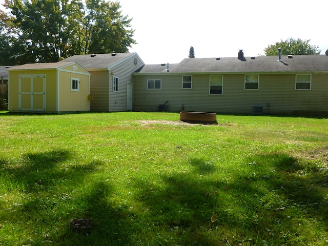 back of property with a yard and a storage unit