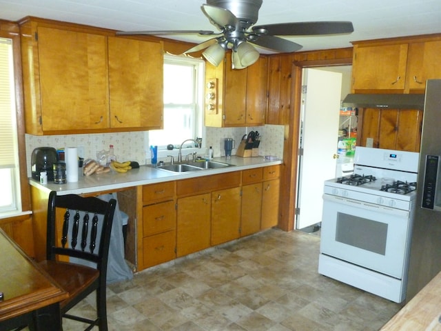 kitchen with ceiling fan, white appliances, sink, and tasteful backsplash